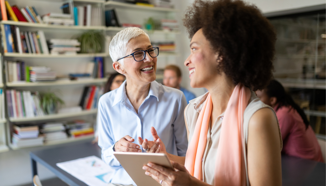 Two women smiling and talking in an office setting